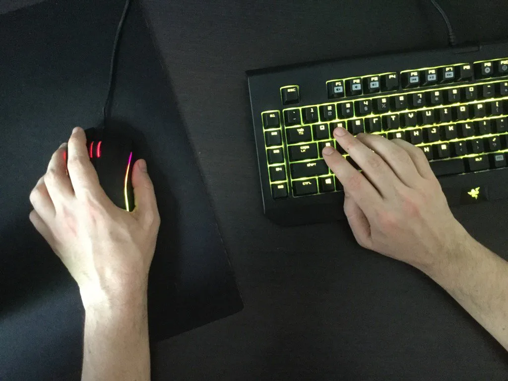 a top down view of a left handed person using keyboard and mouse